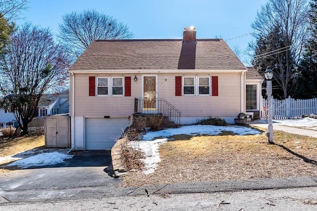 view of front of home featuring a garage, fence, driveway, roof with shingles, and a chimney