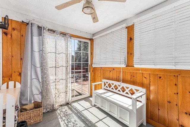 interior space featuring wood walls and ceiling fan