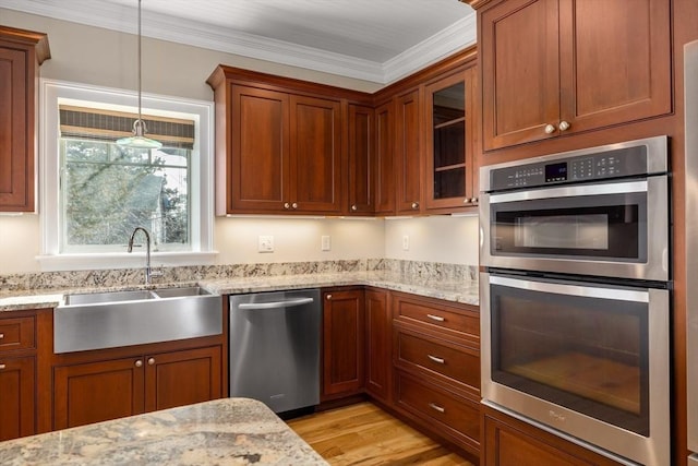 kitchen featuring a sink, appliances with stainless steel finishes, light wood-type flooring, glass insert cabinets, and crown molding