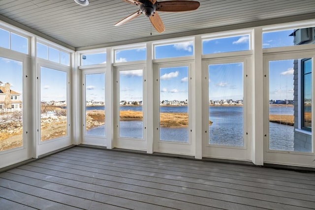 unfurnished sunroom featuring a ceiling fan and a water view