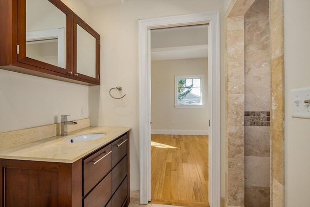 bathroom featuring vanity, baseboards, and wood finished floors