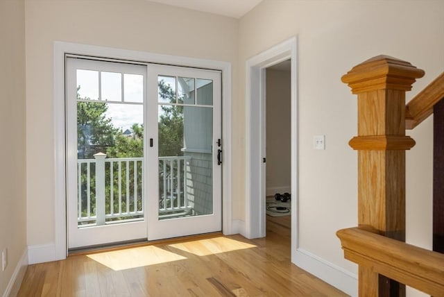 doorway featuring wood finished floors and baseboards