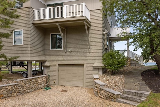 view of front of house with an attached garage and a balcony