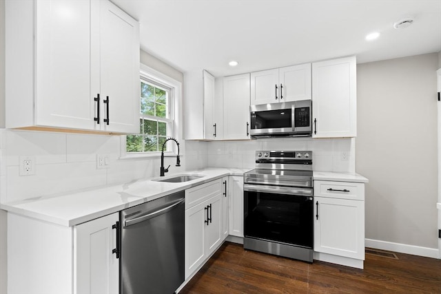 9 Bishop Rd, Quincy, MA 02170 - kitchen featuring stainless steel appliances, a sink, dark wood-style flooring, backsplash, and recessed lighting
