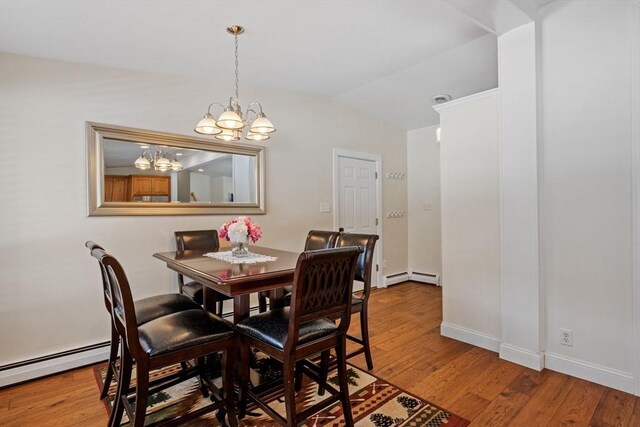 113 Glen Rd, Gorham, NH 03581 - dining space with baseboard heating, a chandelier, wood finished floors, vaulted ceiling, and baseboards