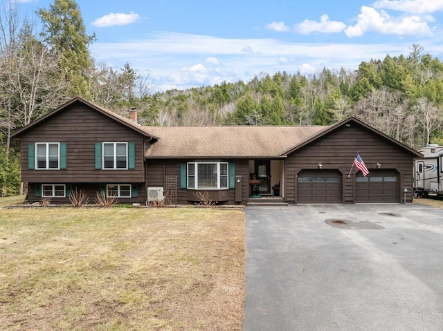 113 Glen Rd, Gorham, NH 03581 - split level home featuring a chimney, asphalt driveway, a garage, and a front lawn