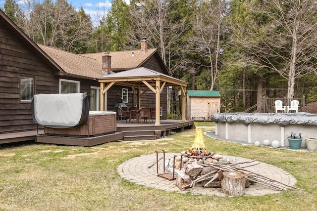 113 Glen Rd, Gorham, NH 03581 - rear view of house featuring an outdoor fire pit, a chimney, a deck, a storage unit, and a gazebo