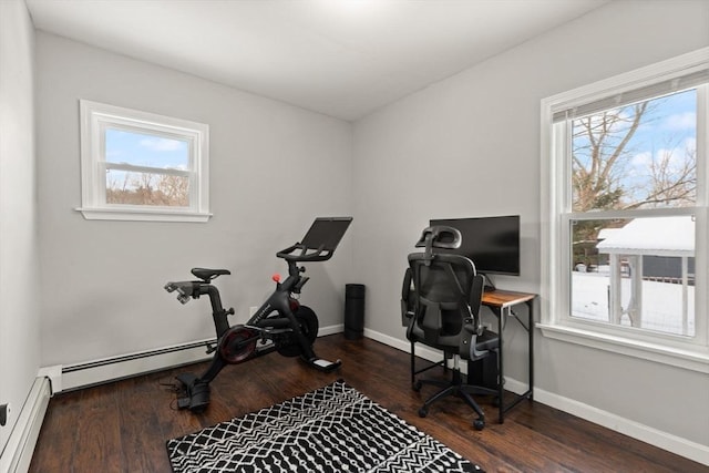 home office with a baseboard radiator, a healthy amount of sunlight, and dark wood-type flooring