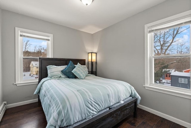 bedroom with baseboard heating and dark wood-type flooring