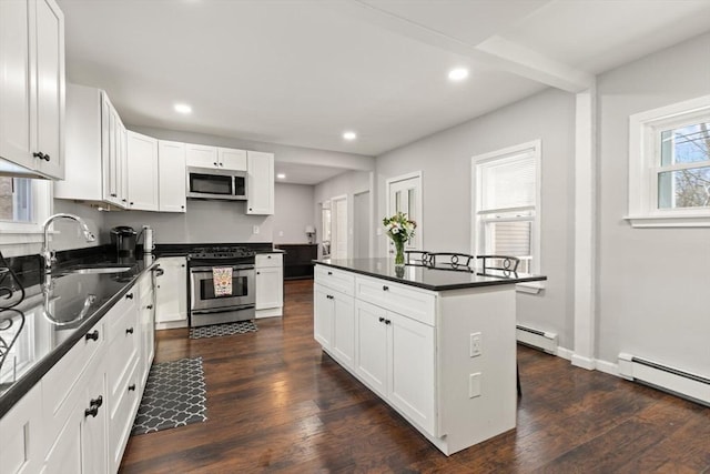 kitchen with a baseboard radiator, a center island, white cabinetry, stainless steel appliances, and sink