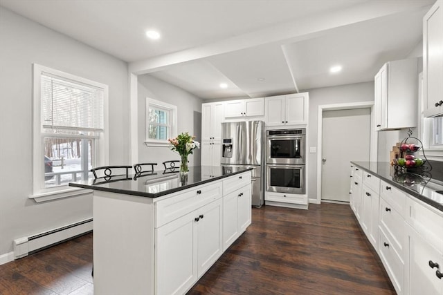 kitchen featuring a baseboard radiator, white cabinets, dark hardwood / wood-style floors, a kitchen island, and stainless steel appliances