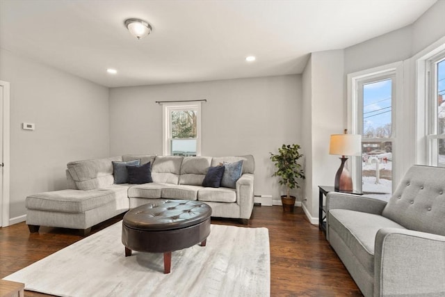 living room with baseboard heating and dark hardwood / wood-style flooring