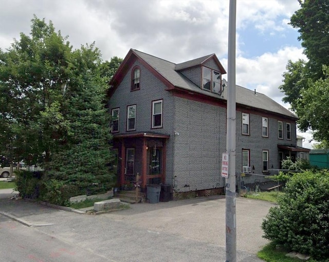 view of property exterior with brick siding and cooling unit