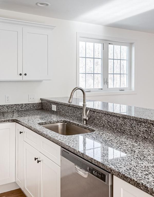 kitchen featuring stone countertops, sink, white cabinetry, and dishwasher