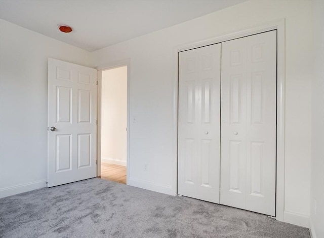 unfurnished bedroom featuring light colored carpet and a closet