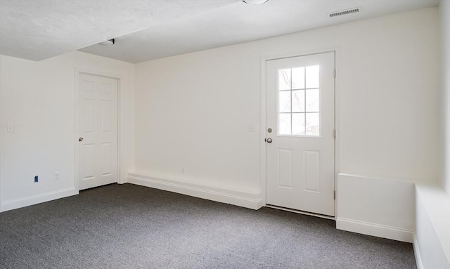 doorway with dark colored carpet