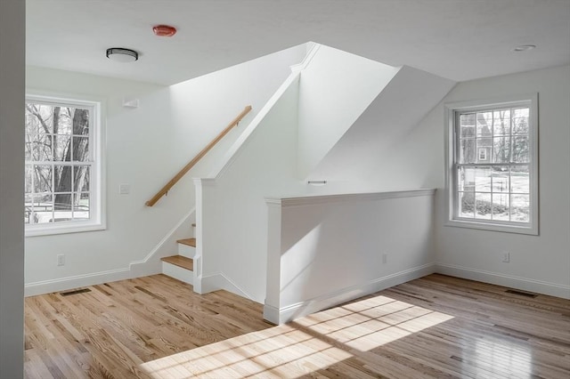 additional living space featuring light hardwood / wood-style flooring and vaulted ceiling