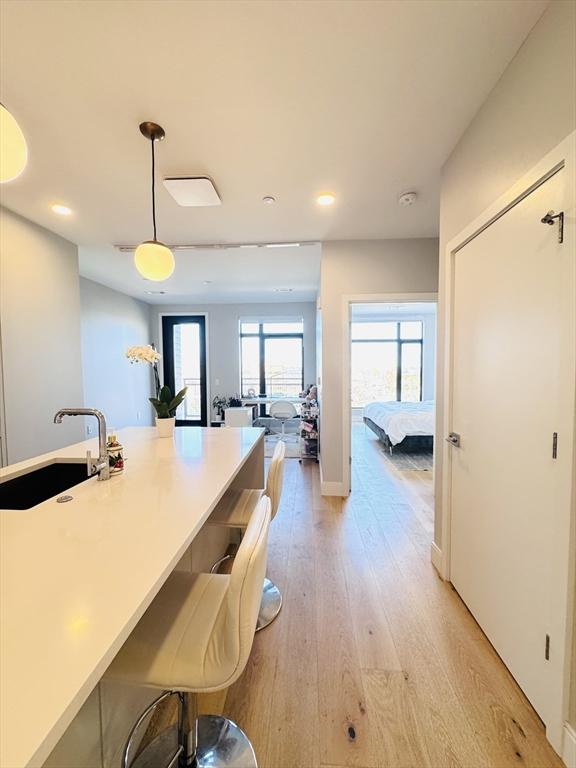 kitchen featuring a sink, light wood-style floors, pendant lighting, and recessed lighting