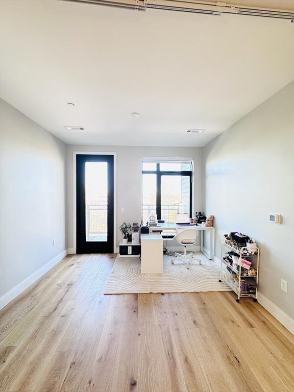 office space featuring baseboards and light wood finished floors