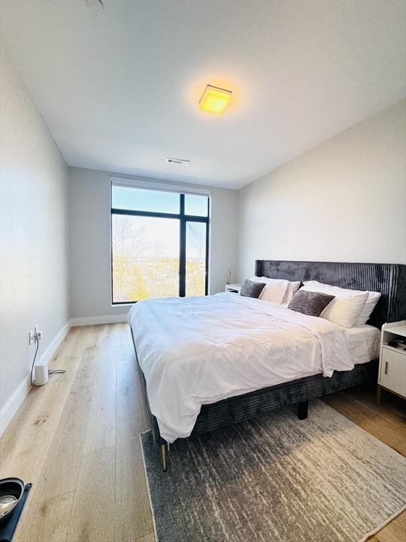 bedroom with light wood-type flooring, baseboards, and visible vents