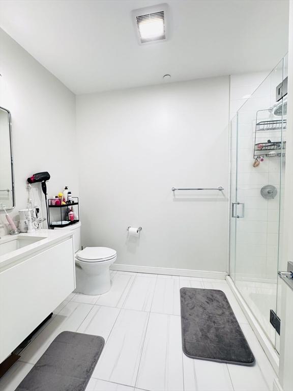 full bath with vanity, toilet, visible vents, and a stall shower