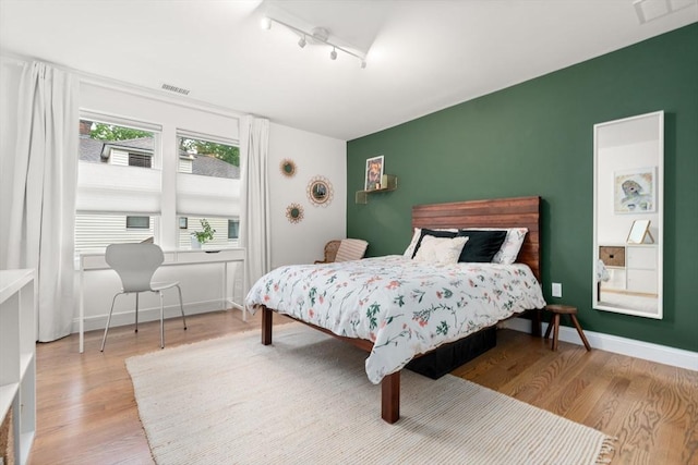 323 Lake Ave Unit 323, Newton, MA 02461 - bedroom featuring wood finished floors, track lighting, an accent wall, a desk, and baseboards