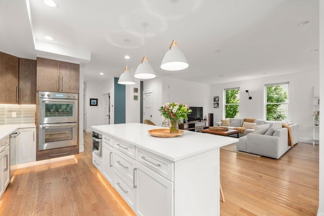 323 Lake Ave Unit 323, Newton, MA 02461 - kitchen with stainless steel appliances, light wood-style floors, a kitchen island, light countertops, and recessed lighting