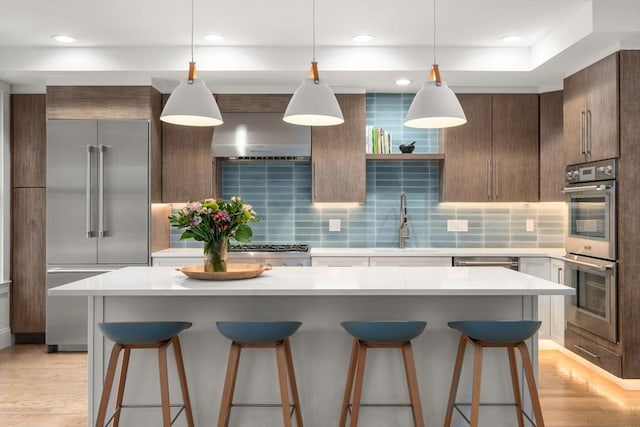 323 Lake Ave Unit 323, Newton, MA 02461 - kitchen featuring stainless steel appliances, a sink, a kitchen bar, light countertops, and recessed lighting