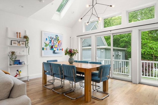 323 Lake Ave Unit 323, Newton, MA 02461 - dining room featuring a skylight, wood finished floors, high vaulted ceiling, baseboards, and a chandelier