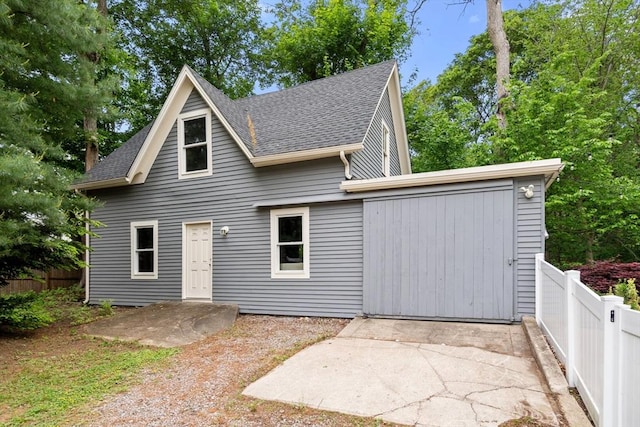 323 Lake Ave Unit 323, Newton, MA 02461 - view of front of house with a shingled roof, a fenced backyard, and a patio area