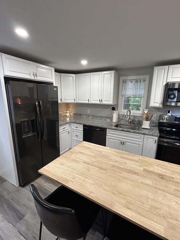 1 Sunderland Ter, Worcester, MA 01604 - kitchen featuring black appliances, wood finished floors, white cabinetry, stone counters, and recessed lighting