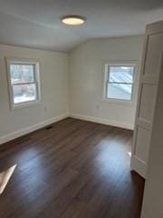 additional living space with dark wood-type flooring