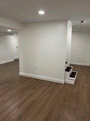 basement with dark hardwood / wood-style flooring