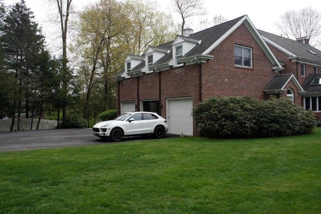 view of side of home featuring a yard and a garage