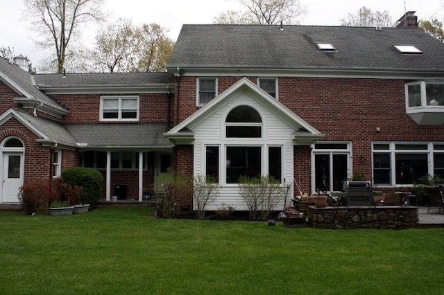 rear view of property with a patio and a lawn