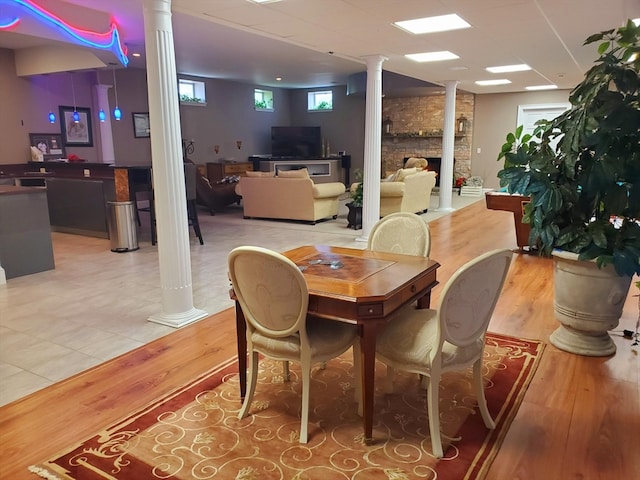 dining room featuring ornate columns, tile floors, and a fireplace