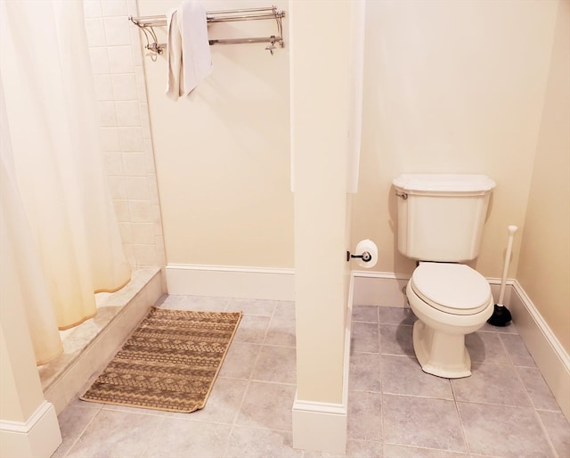 bathroom with curtained shower, toilet, and tile flooring