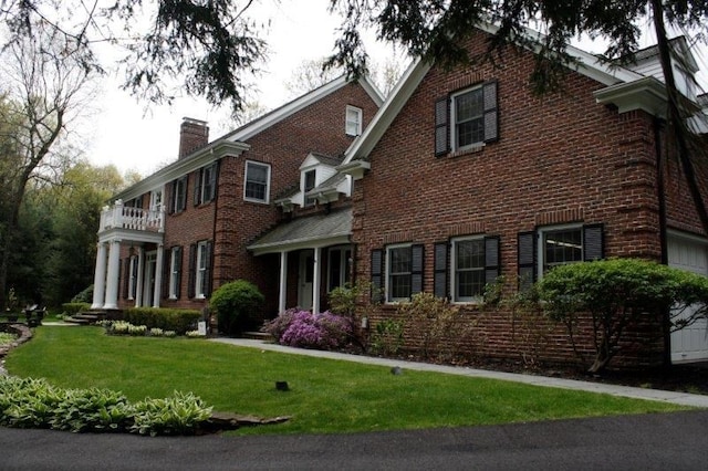 view of front of property with a balcony and a front yard