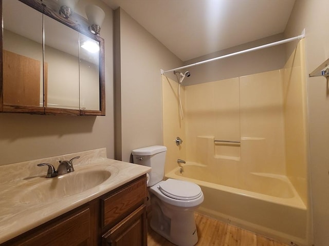 bathroom featuring toilet, vanity, wood finished floors, and shower / bathtub combination