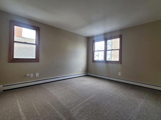 empty room with a baseboard heating unit and carpet flooring