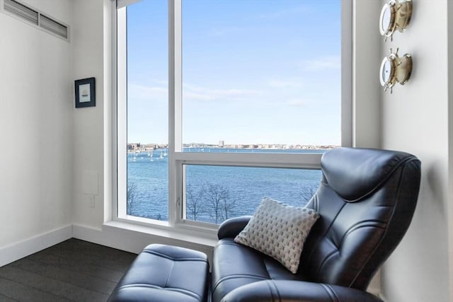 living area featuring a water view and dark hardwood / wood-style floors