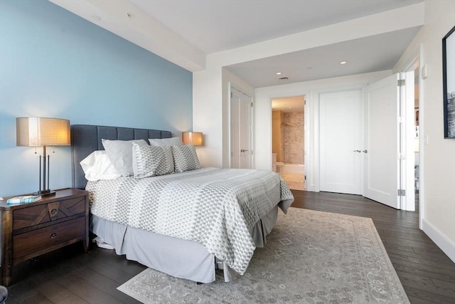 bedroom featuring dark hardwood / wood-style flooring and ensuite bath