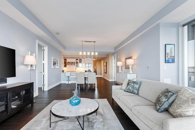 living room featuring dark wood-type flooring and a chandelier