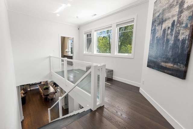 stairs with crown molding, baseboards, visible vents, and wood-type flooring