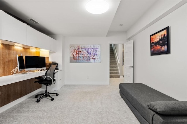 office area featuring built in study area, baseboards, light carpet, and visible vents