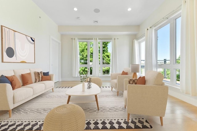 living room featuring baseboards, light wood finished floors, and recessed lighting