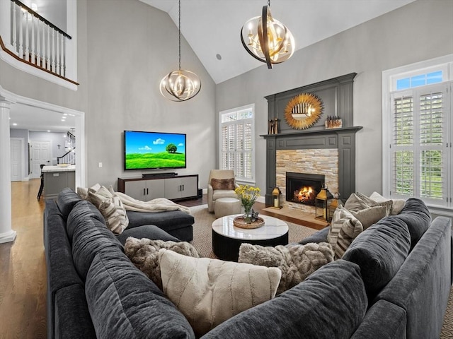 17 Olde Hickory Path, Westborough, MA 01581 - living room with high vaulted ceiling, a chandelier, a stone fireplace, wood finished floors, and decorative columns