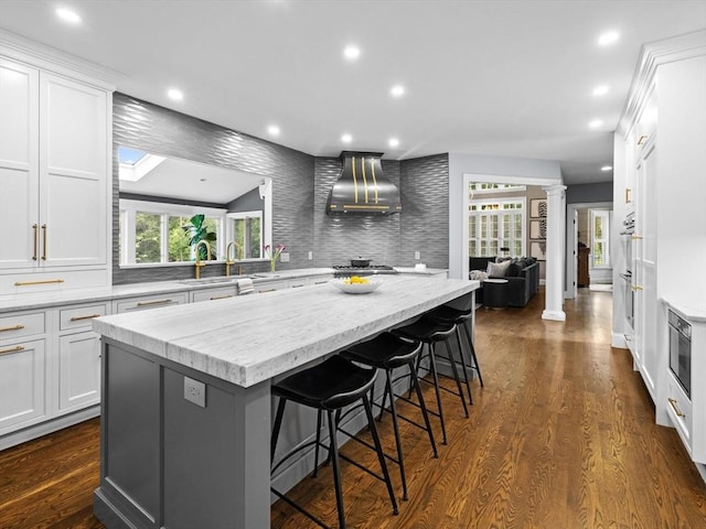 17 Olde Hickory Path, Westborough, MA 01581 - kitchen with ornate columns, white cabinetry, a center island, a kitchen bar, and recessed lighting