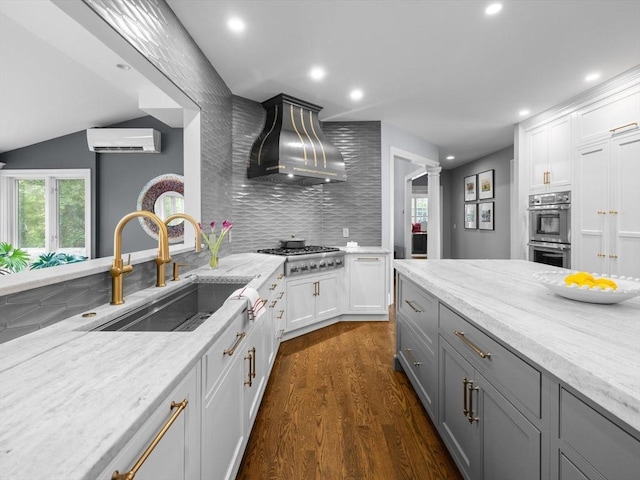 17 Olde Hickory Path, Westborough, MA 01581 - kitchen featuring ventilation hood, appliances with stainless steel finishes, a wall unit AC, backsplash, and recessed lighting