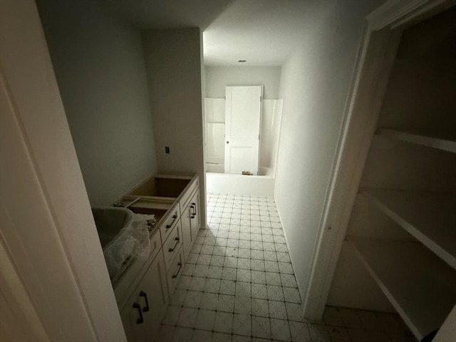 bathroom featuring tile patterned floors, a bathtub, and double vanity